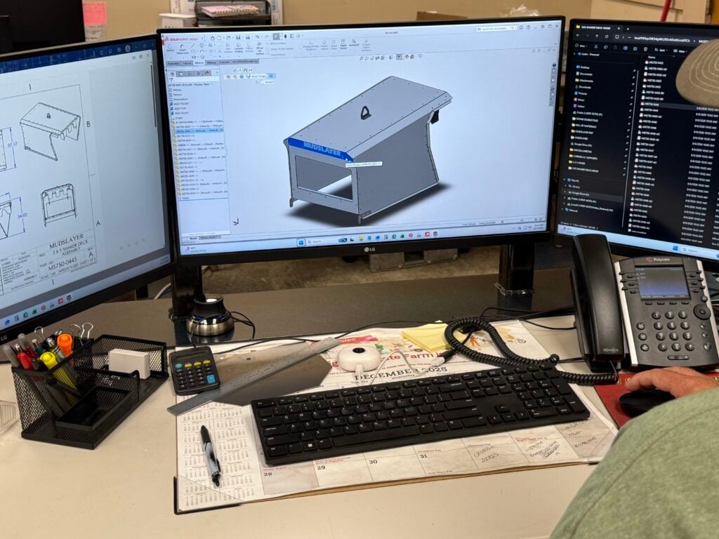 CAD model and part drawing on an engineer's screens during a design for manufacturability review