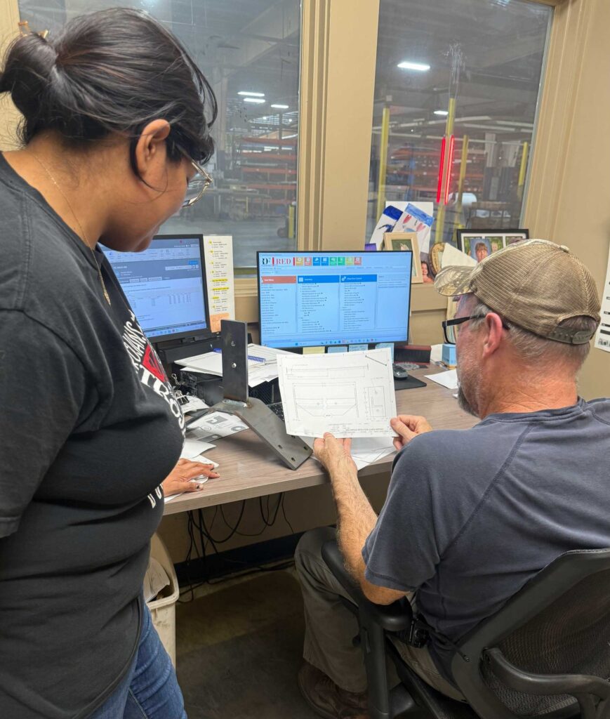 Red Oak team members reviewing a part drawing at a CAD workstation