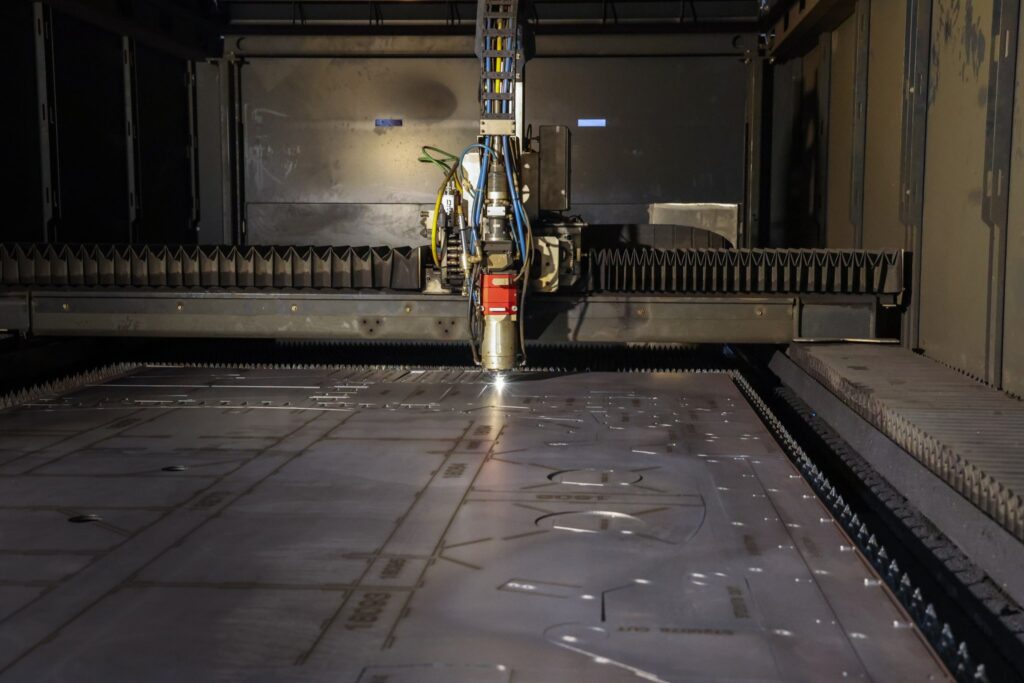 Fiber laser cutting head cutting steel plate on the laser bed