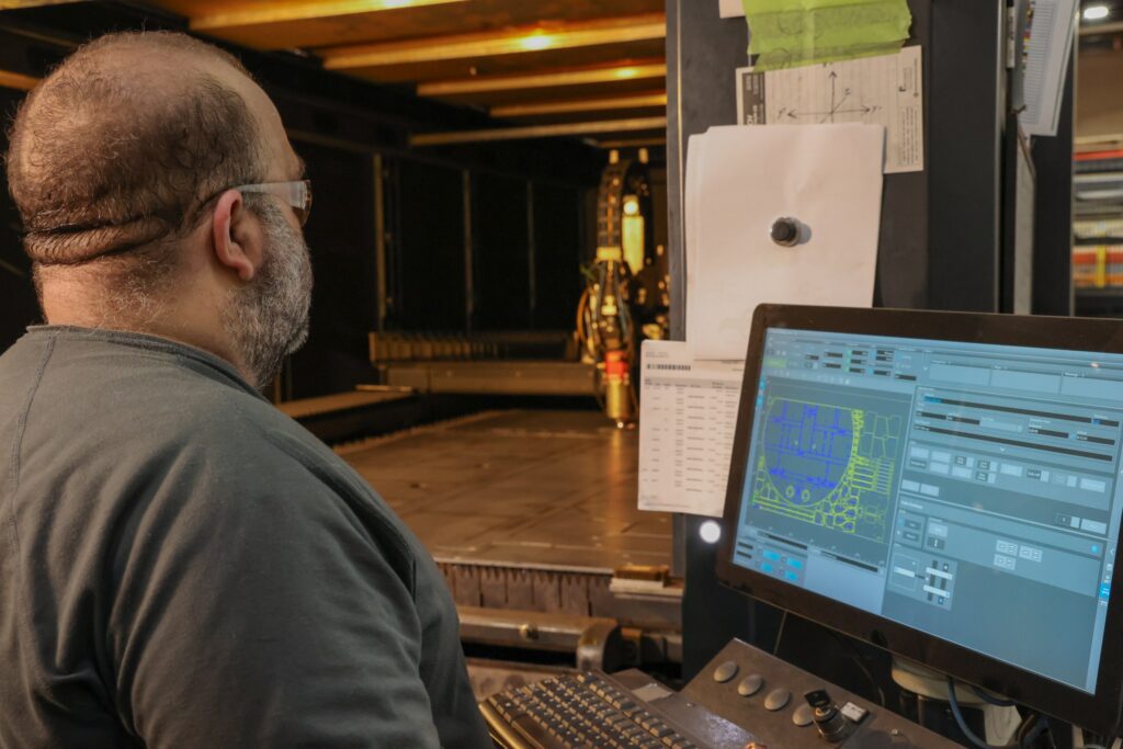 Operator watching a fiber laser cut from the control station