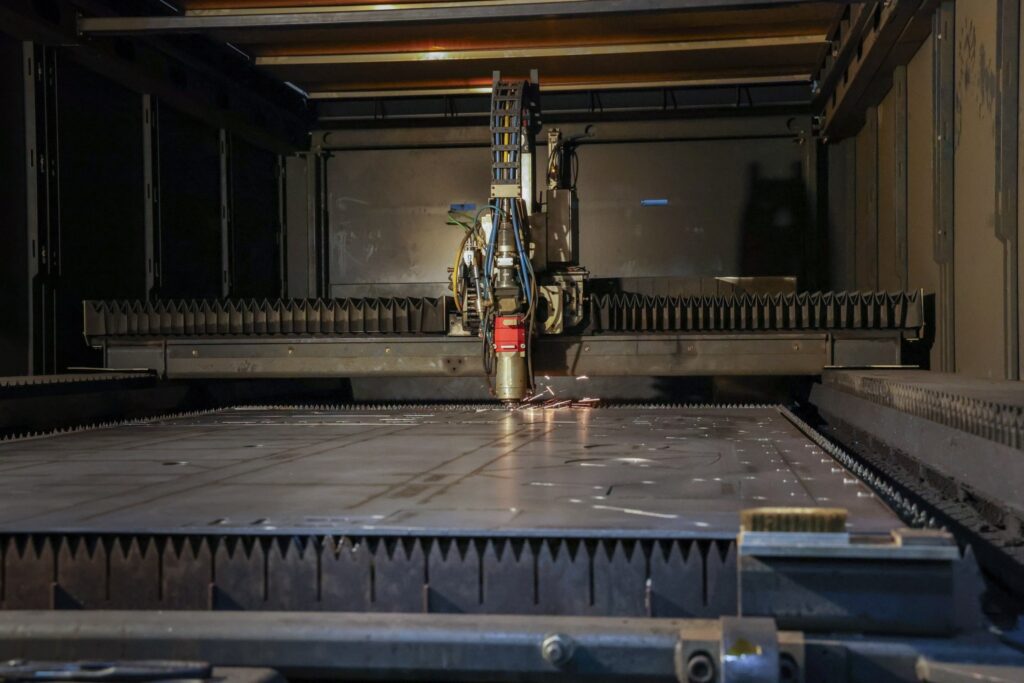 Laser cutting head cutting sheet metal on a flatbed laser