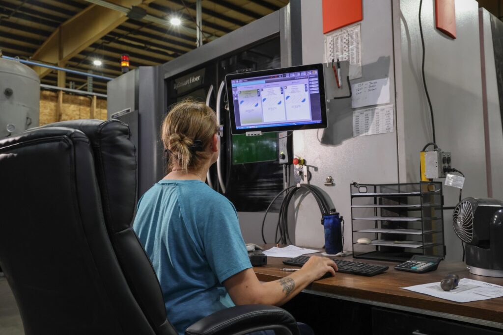 Operator running a laser cutting job from the machine control station