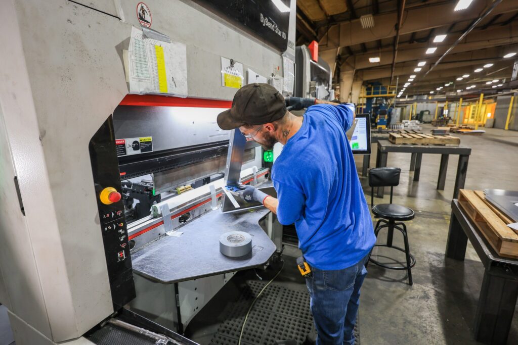Operator bending sheet metal on a Bystronic CNC press brake